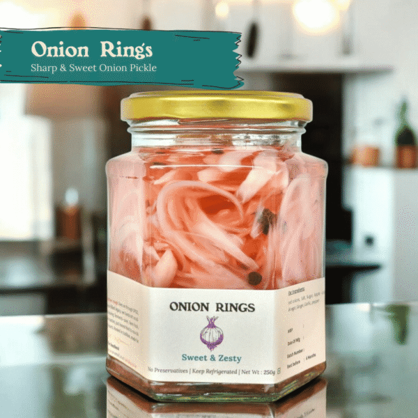 Glass jar of Spiso Onion Rings Pickled Red Onions on a wooden surface with sliced onions